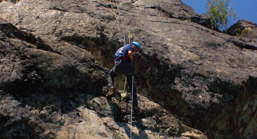 an outward bound student climbs a rock wall on an expedition in the pacific northwest